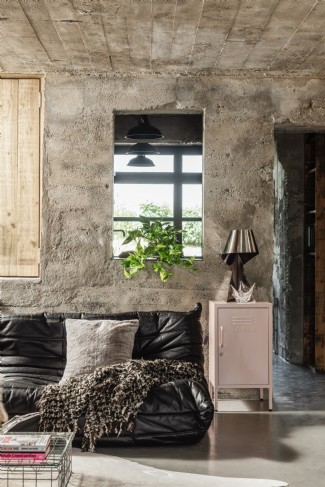 The kitchen is visible through an opening in the concrete