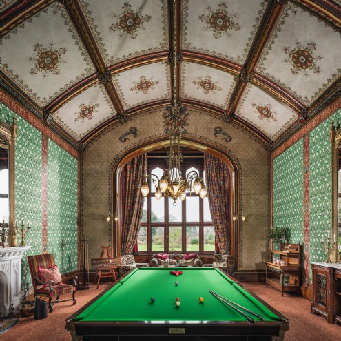 The formal hall, complete with a billiards table, with Pugin-designed wallpaper
