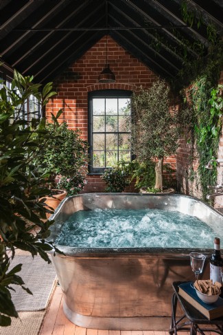 The giant tin-clad copper hot tub welcomes lazy evenings in the orangery